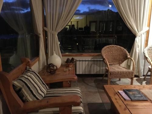 a living room with chairs and a table and a window at Estancia Del Carmen Mountain Resort in San Carlos de Bariloche