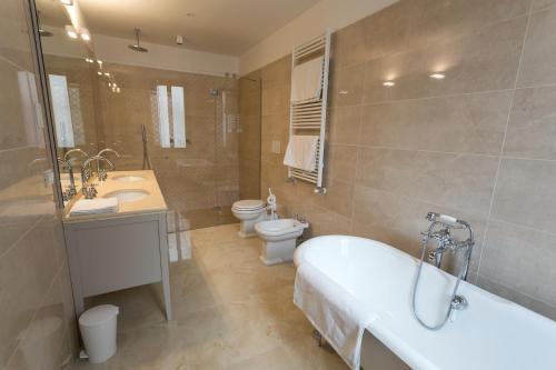 un bagno con vasca, WC e lavandino di Guest House Ca' dell'Angelo a Venezia