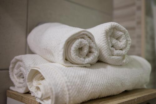 a pile of towels sitting on a shelf in a bathroom at Apartment Impression in Osijek