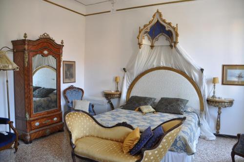 a bedroom with a canopy bed and a chair at La Chambre D'Ella in Venice
