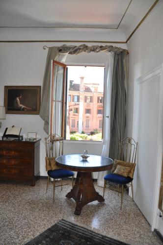 a room with a table and chairs and a window at La Chambre D'Ella in Venice