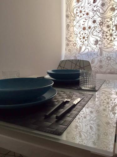a table with two blue plates and silverware on it at Mini appartamenti a Catanzaro Lido in Catanzaro Lido