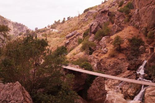 a bridge on the side of a mountain with a waterfall at Casa de la Placeta del Rincón in Moclín