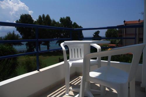 two white chairs on a balcony with a view of the water at Lydia Rooms & Studios in Preveza