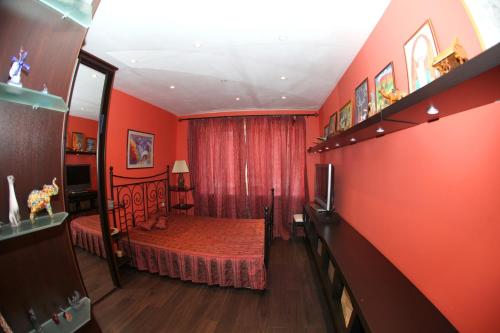 a bedroom with a bed and a red wall at Аксакова,72 Трехкомнатные апартаменты in Ufa