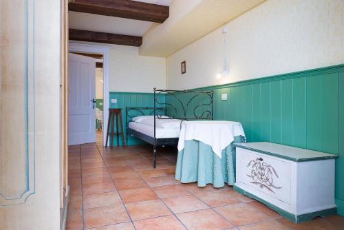 a bedroom with a bed with green walls and a tile floor at Quinz - Locanda Al Lago in Misurina