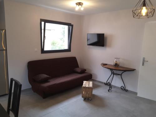 Villa'vi Lyon Est Chambres d'Hôtes في سانت-بريست: غرفة معيشة مع أريكة وطاولة