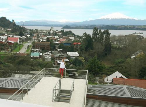 a person standing on the edge of a roof at Dein Haus Hotel y Departamentos in Puerto Varas