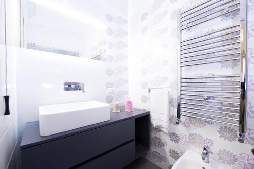 La salle de bains blanche est pourvue d'un lavabo et d'un miroir. dans l'établissement Casa "Aurora" Atrani - Amalfi coast - beach, à Atrani