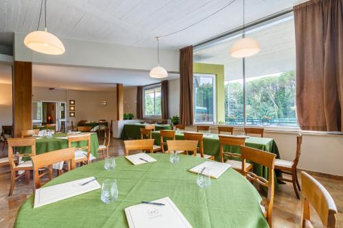 a dining room with a green table and chairs at Hotel Country Club in Capannori