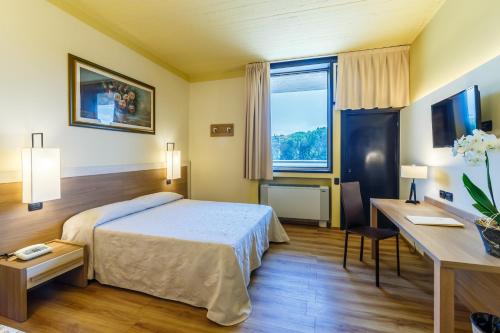 a hotel room with a bed and a desk at Hotel Country Club in Capannori