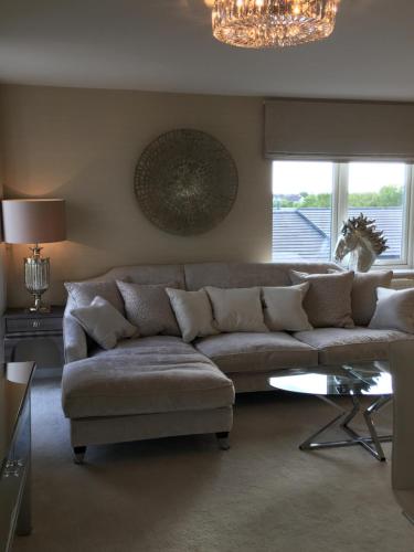 a living room with a couch and a chandelier at Cardiff luxury apartments in Cardiff