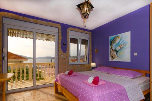 a bedroom with a bed and a balcony at Stonehouse with swimming pool Villa Anita in Okrug Donji