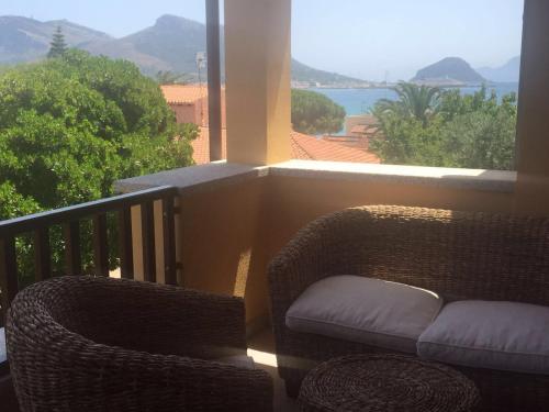 ゴルフォ・アランチにあるvilla aranciの海の景色を望むバルコニー(籐の椅子付)