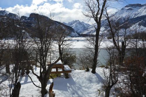 a view of a snow covered lake and mountains at Camping Rio de las Vueltas in El Chalten