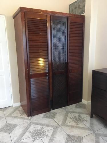 a pair of wooden doors in a room with a tile floor at One Hamilton Place - Emerald in Choiseul