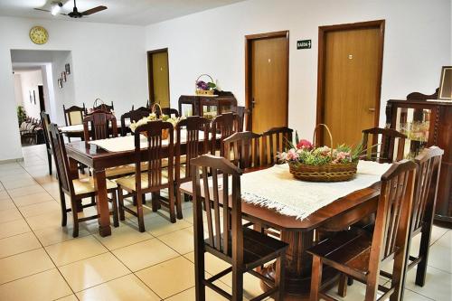 a dining room with a table and chairs with flowers on it at Pousada Alvorada Brotas - e agendamento das atividades turísticas in Brotas
