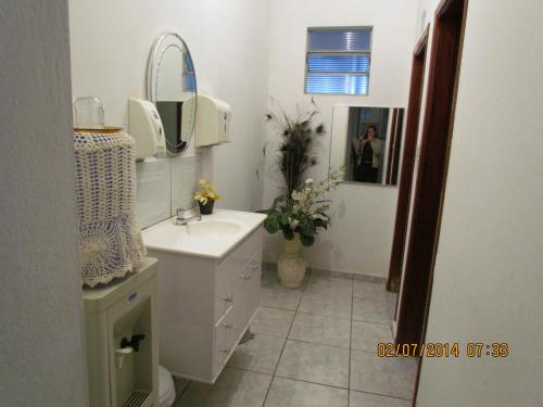 a white bathroom with a sink and a mirror at Pousada Alvorada Brotas - e agendamento das atividades turísticas in Brotas