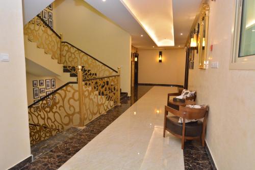 a hallway with a staircase with a chair and a stair case at Arto Aparthotel in Riyadh