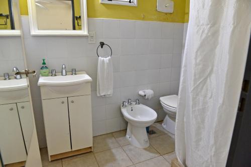 y baño con lavabo, aseo y espejo. en Posada Via Verde en Gualeguaychú