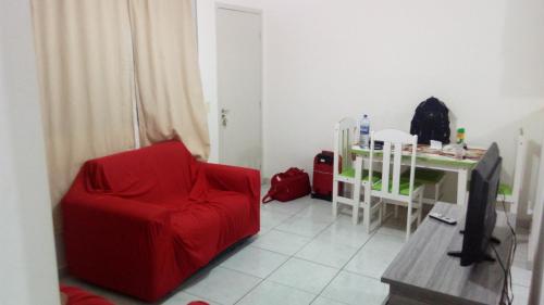 sala de estar con silla roja y mesa en Apartamento em Natal/RN, en Natal