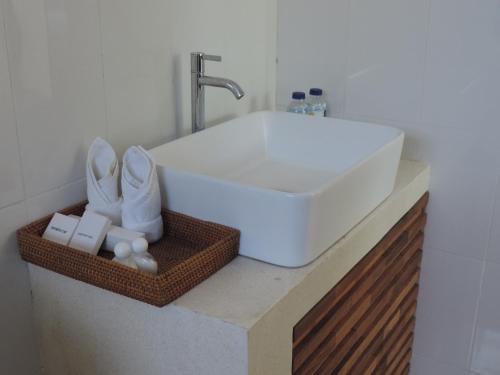 a bathroom sink with white towels and a faucet at Kencana Ubud by Mahaputra in Ubud