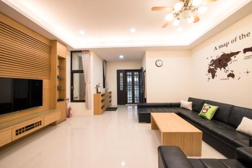a living room with a black couch and a tv at Travel Friends in Huxi