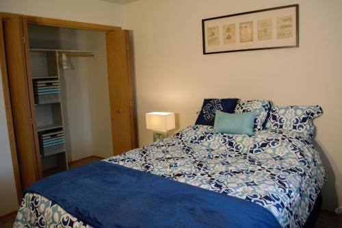 Schlafzimmer mit einem Bett mit blauer Decke in der Unterkunft 8635 Ustick Road Apartment in Boise