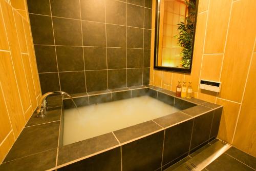 y baño con bañera y lavamanos. en Hosta Toji San, en Kioto