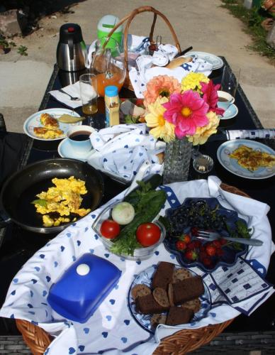 a table with plates of food and flowers on it at Gästezimmer Sommer Locktow in Locktow