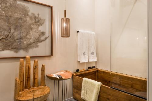 ハニア・タウンにあるAisha Petite Suitesのバスルーム(木製のバスタブ、木製の椅子付)