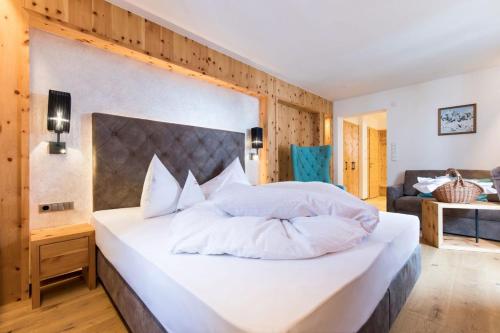 a bedroom with a large bed with white pillows at Hotel Eden in Solda