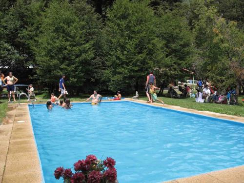 a group of people playing in a swimming pool at Cabañas Blanche Neige Wellness & SPA in Las Trancas