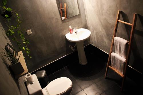 Un baño con lavabo, inodoro y espejo. en The Courtyard Villa, en Sigiriya