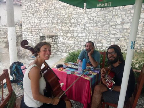 a group of people sitting at a table under an umbrella at Guest house Hava Baci in Berat