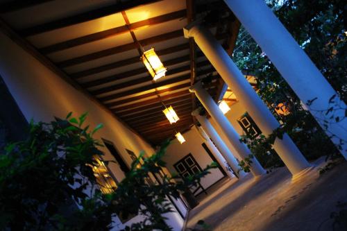 un porche de una casa con luces encendidas en The Courtyard Villa, en Sigiriya