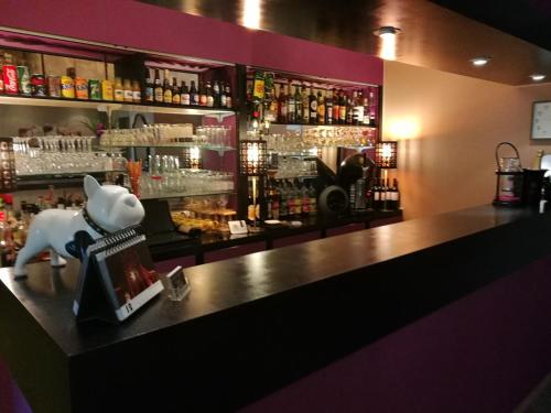 a bar with a cow statue sitting on a counter at Lys Hôtel in Halluin