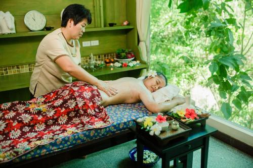 a man giving a woman a massage on a bed at Banburee Resort & All Spa Inclusive in Laem Set Beach