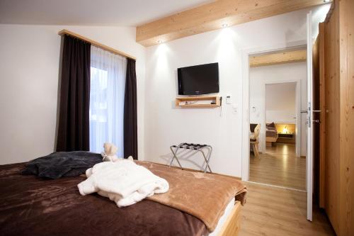 a bedroom with a bed and a tv on the wall at Gästehaus Waldrand Garni in Wiesing