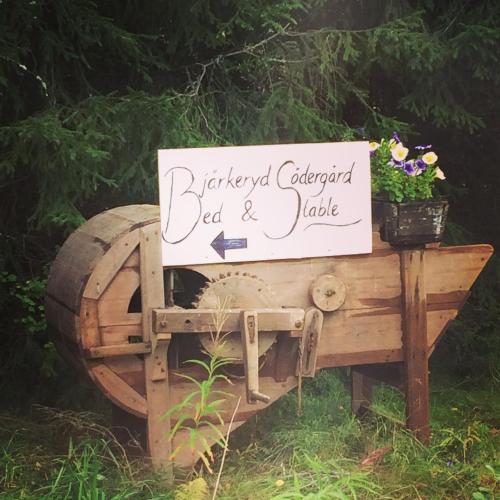 a sign on a wooden barrel with a sign on it at Bjärkeryd Södergård Bed & Stable in Kisa