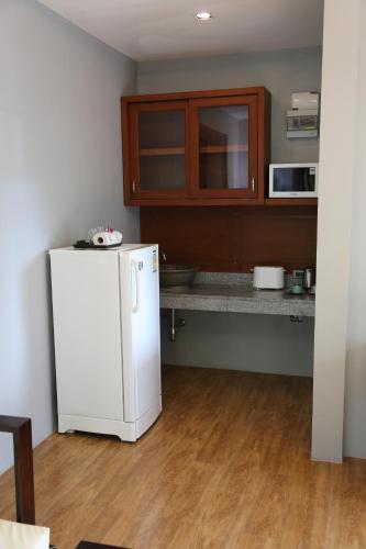 a kitchen with a white refrigerator and a counter at Cocoville Phuket - SHA Plus in Chalong 