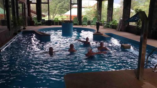 a group of people swimming in a swimming pool at Cabañas Blanche Neige Wellness & SPA in Las Trancas
