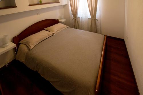 a bed in a bedroom with a wooden headboard at Apartment Sinčić in Novigrad Istria