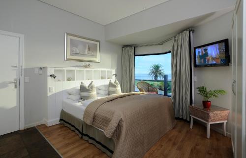 a bedroom with a large bed with a view of the ocean at Oyster Box Guesthouse in Walvis Bay