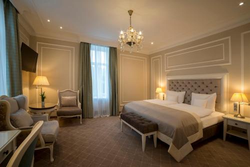 a bedroom with a large bed and a chandelier at Park Hotel & Spa Katharina in Badenweiler