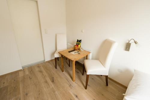 une petite table et une chaise dans une chambre dans l'établissement Hotel Garni Viktoria, à Lindau