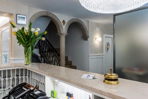 a vase of flowers on a counter in a room at Hotel Guerrini in Venice