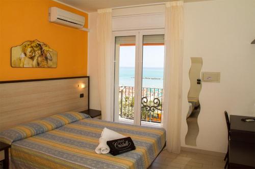 a bedroom with a bed with a view of the ocean at Hotel Cristall in San Benedetto del Tronto