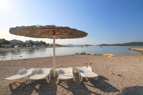 a group of chairs and an umbrella on a beach at Apartment Ana in Vodice