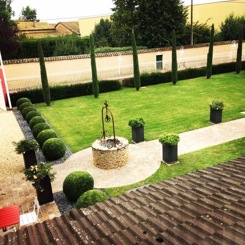 a garden with a fountain in the middle of the grass at Les Maritonnes Parc & Vignoble in Romanèche-Thorins
